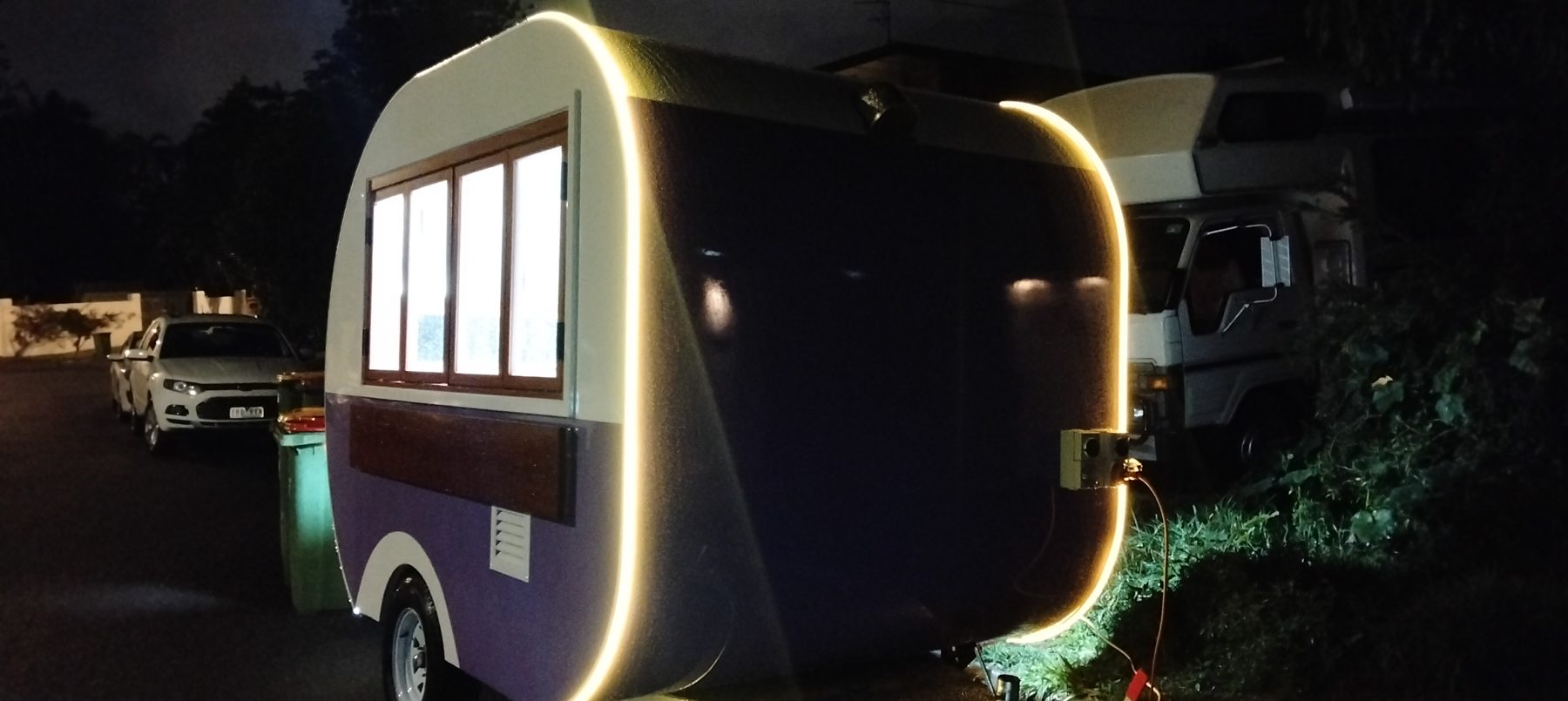 Teardrop trailer with glowing LED lighting at night